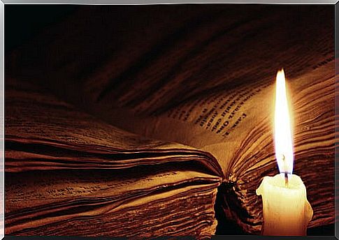 Open book with a burning candle