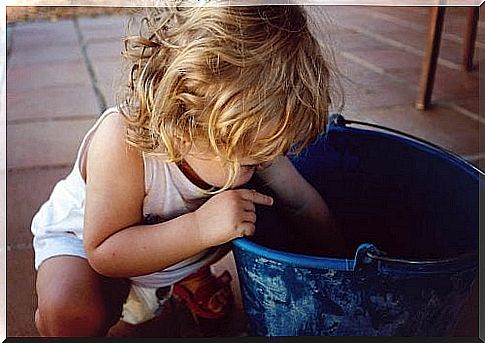 Left-handed boy searching in a bucket