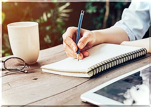 Woman writing down goals in her notebook