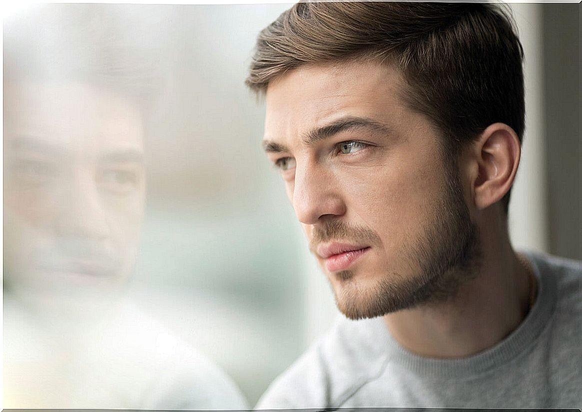 Serious guy looking out the window thinking about realistic expectations