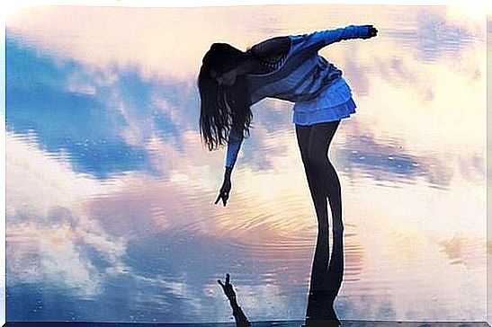 girl touching her reflection in the water